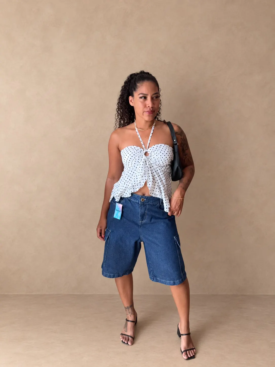 Blusinha Poá branca usada em um look com bermudão jeans.