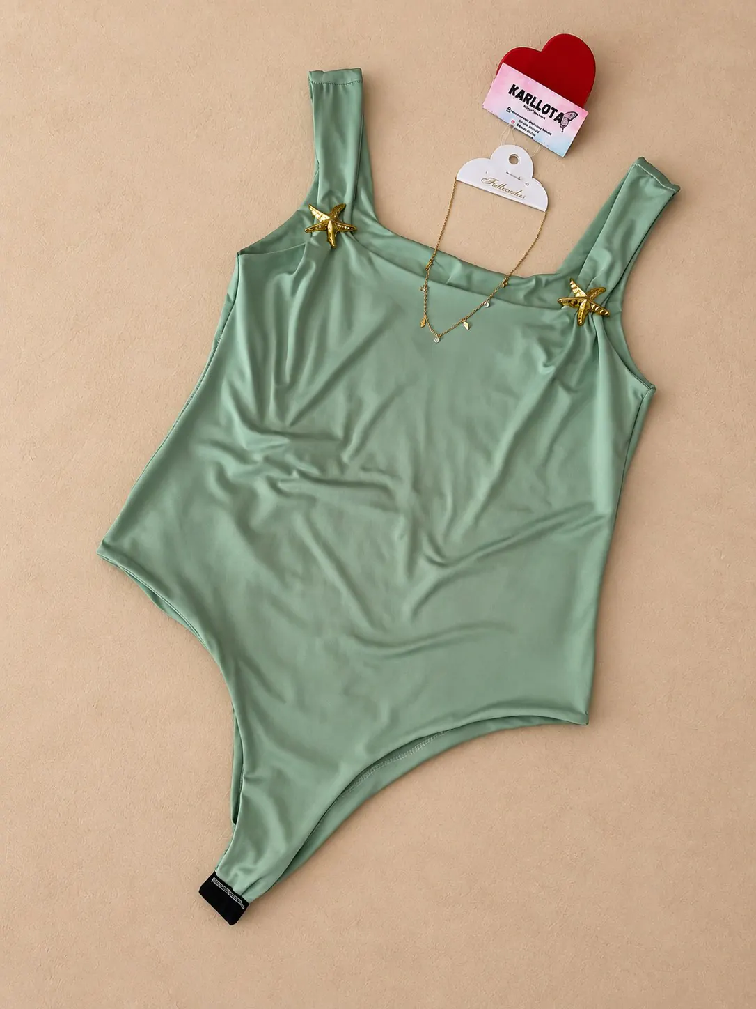Body verde-claro com detalhes de estrelas douradas nas alças.