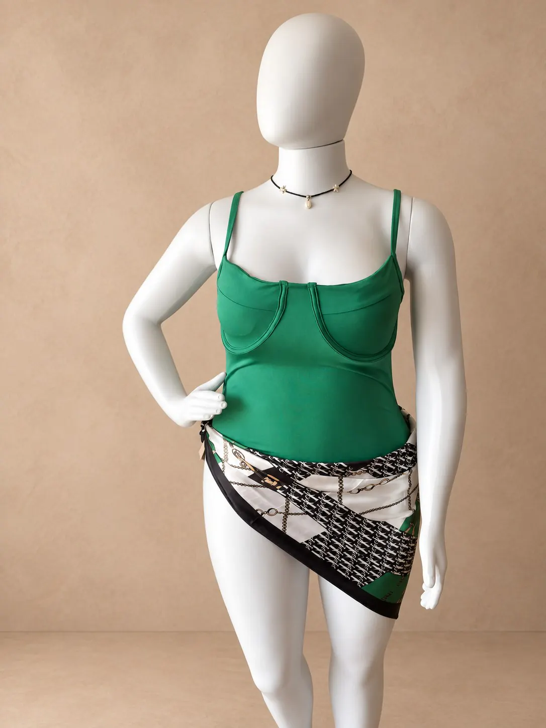 Maiô verde de alças finas combinado com lenço estampado no manequim.