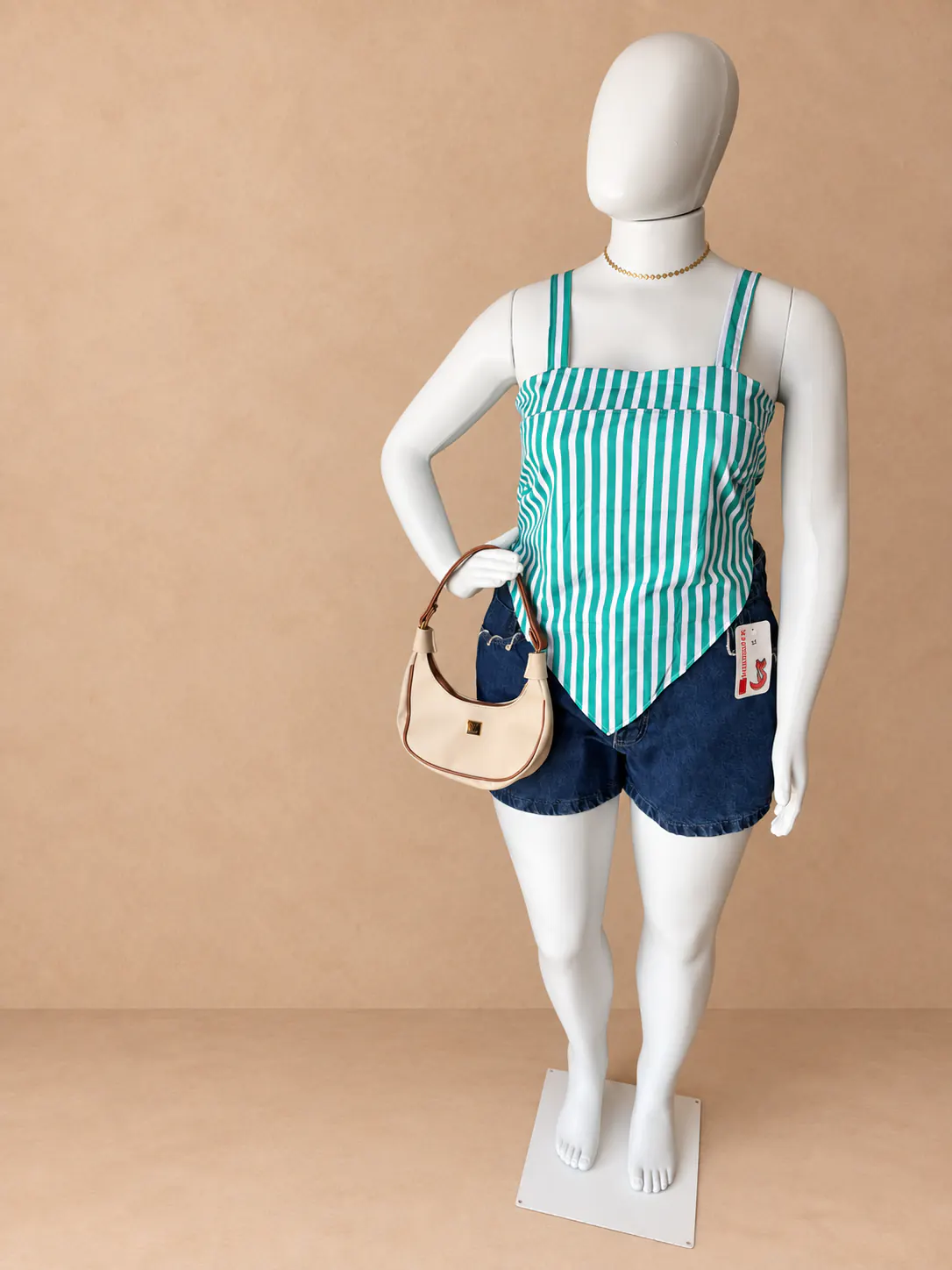 Look Plus com blusa listrada verde e branca e short jeans escuro.