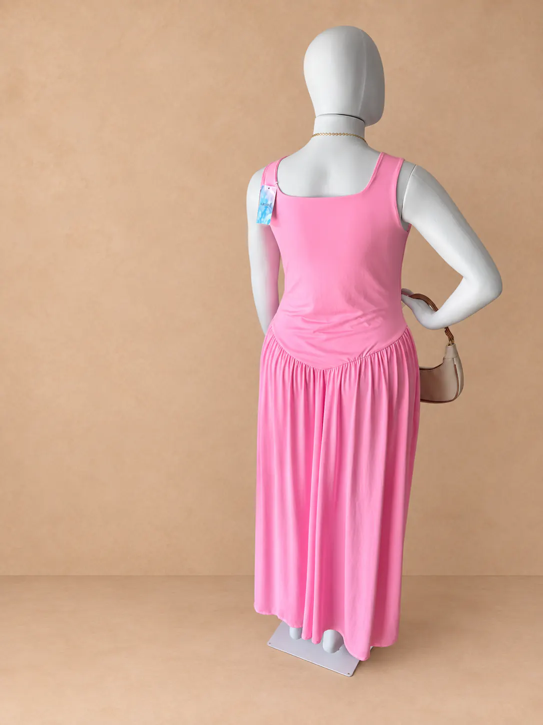 Vestido Assimétrico Plus rosa usado com decote quadrado.