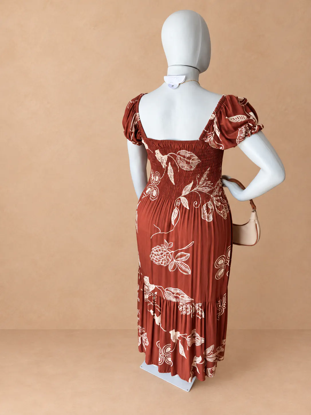 Vestido longo Plus terracota com estampa floral clara, visto por trás.