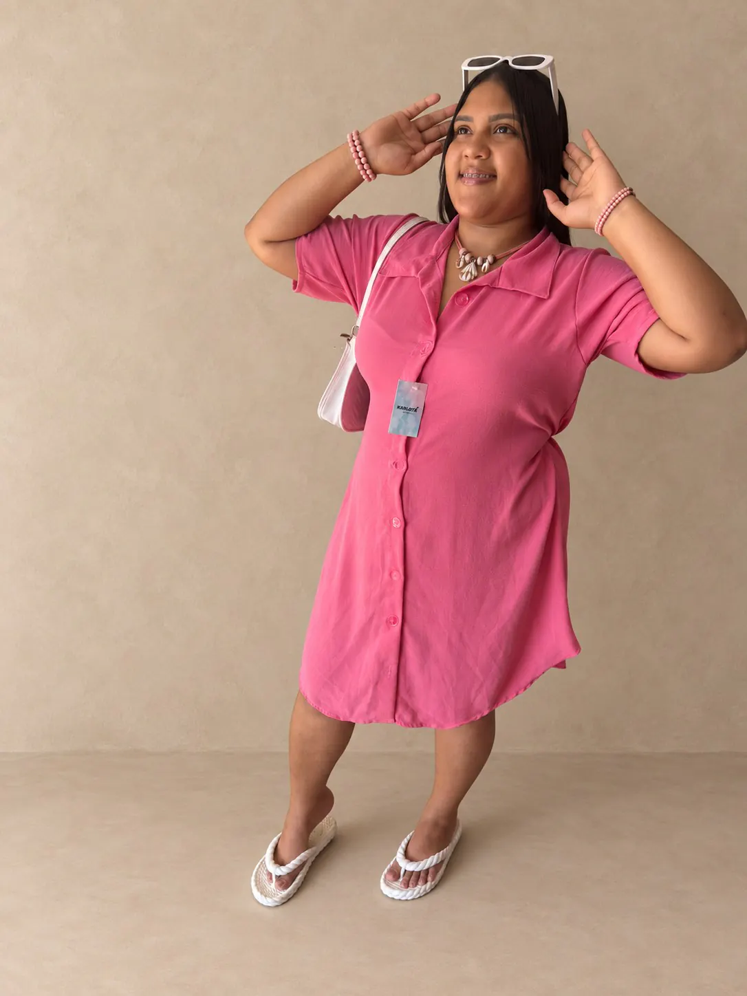 Chemise Plus rosa de mangas curtas, gola e botões na frente.