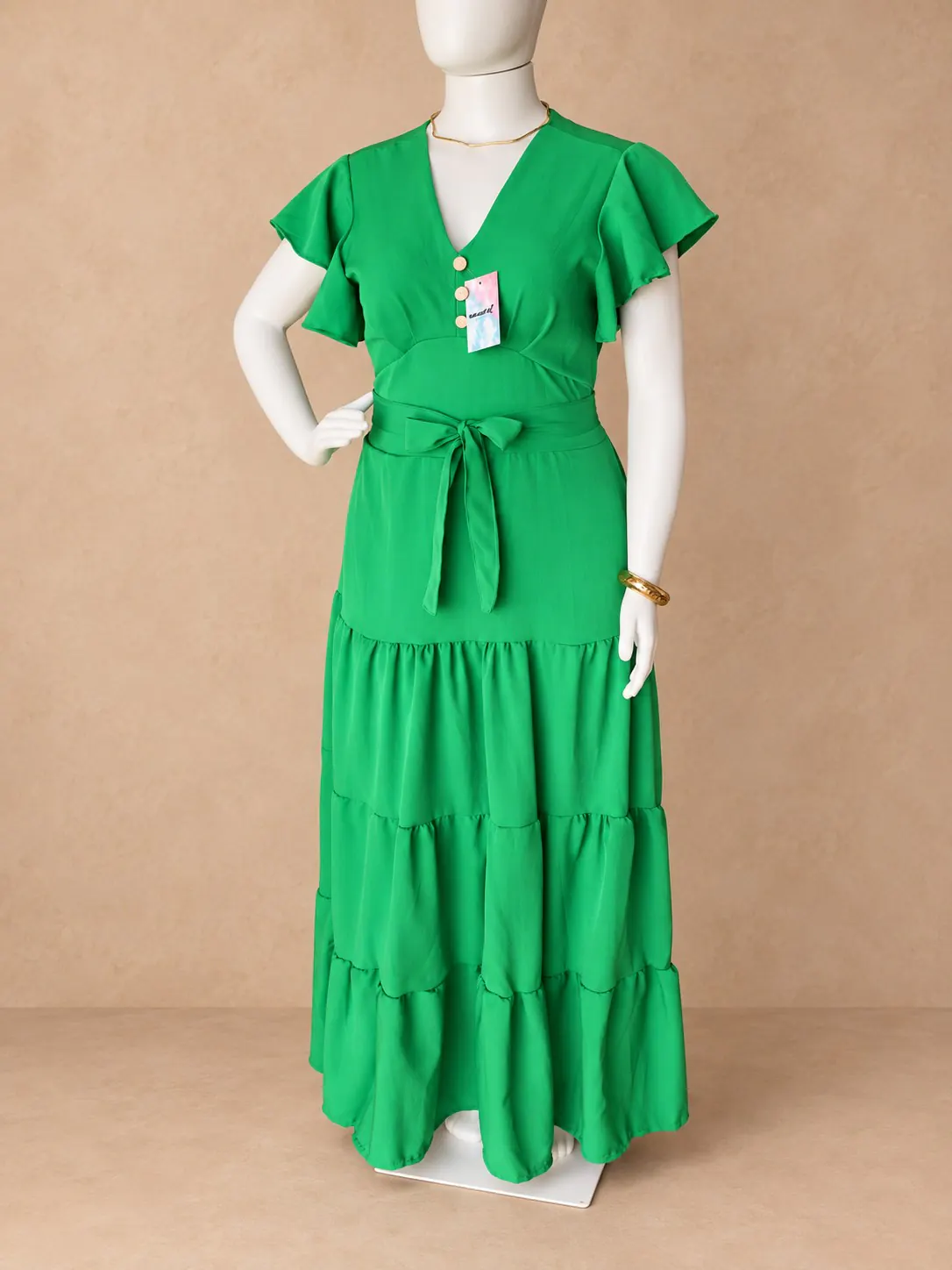 Vestido Festa Plus verde com mangas amplas, faixa na cintura e saia em camadas.