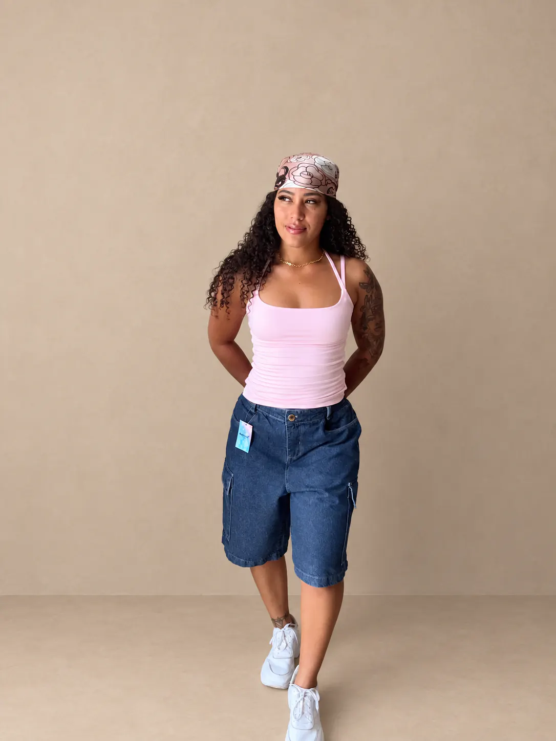 Bermudão jeans cargo escuro usado com blusa modinha rosa.