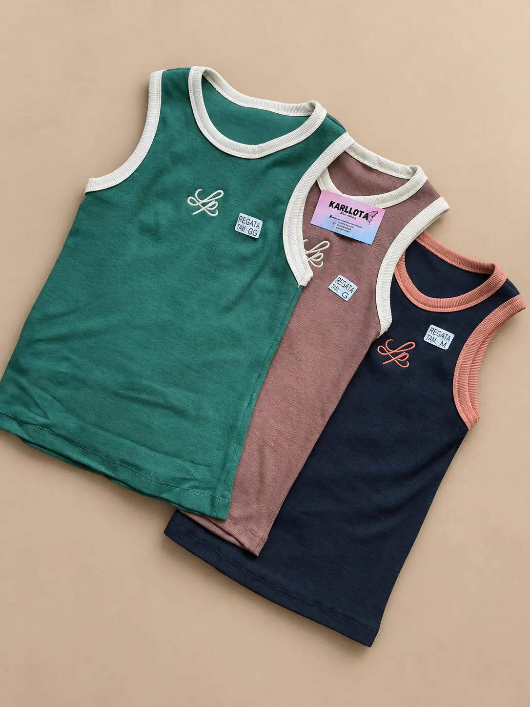 Blusas caneladas Slim nas cores verde, marrom rosado e azul-marinho, sobre fundo areia.