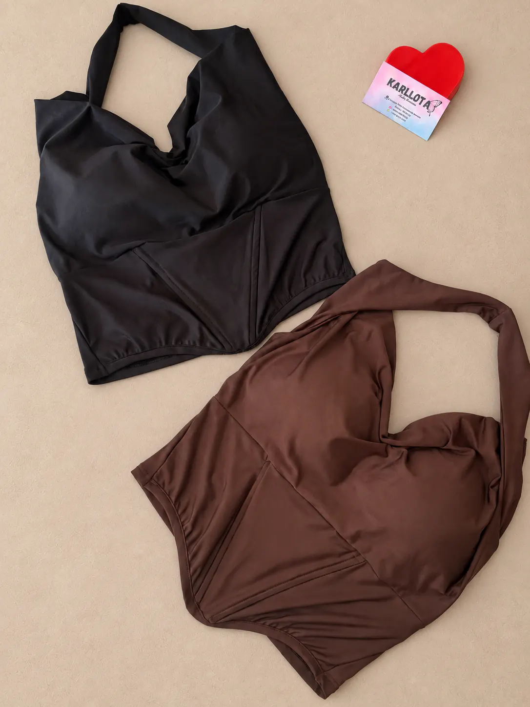 Cropped corset de frente única nas cores preta e marrom, apresentados sobre fundo areia.