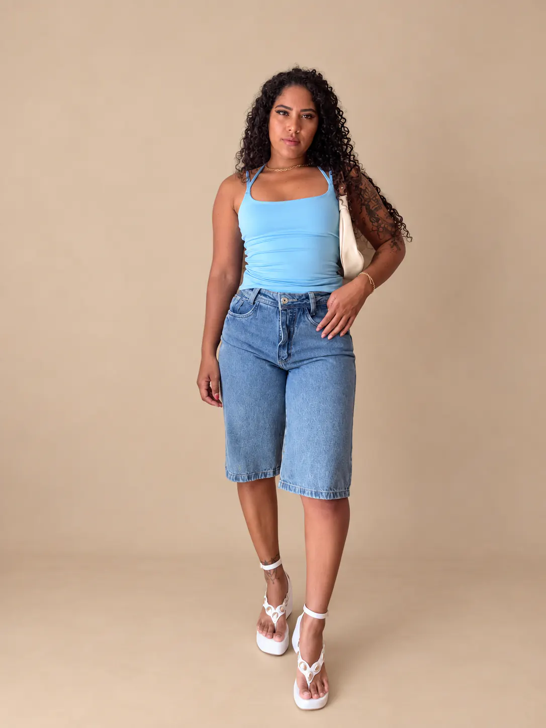 Blusa modinha azul usada com bermudão jeans.