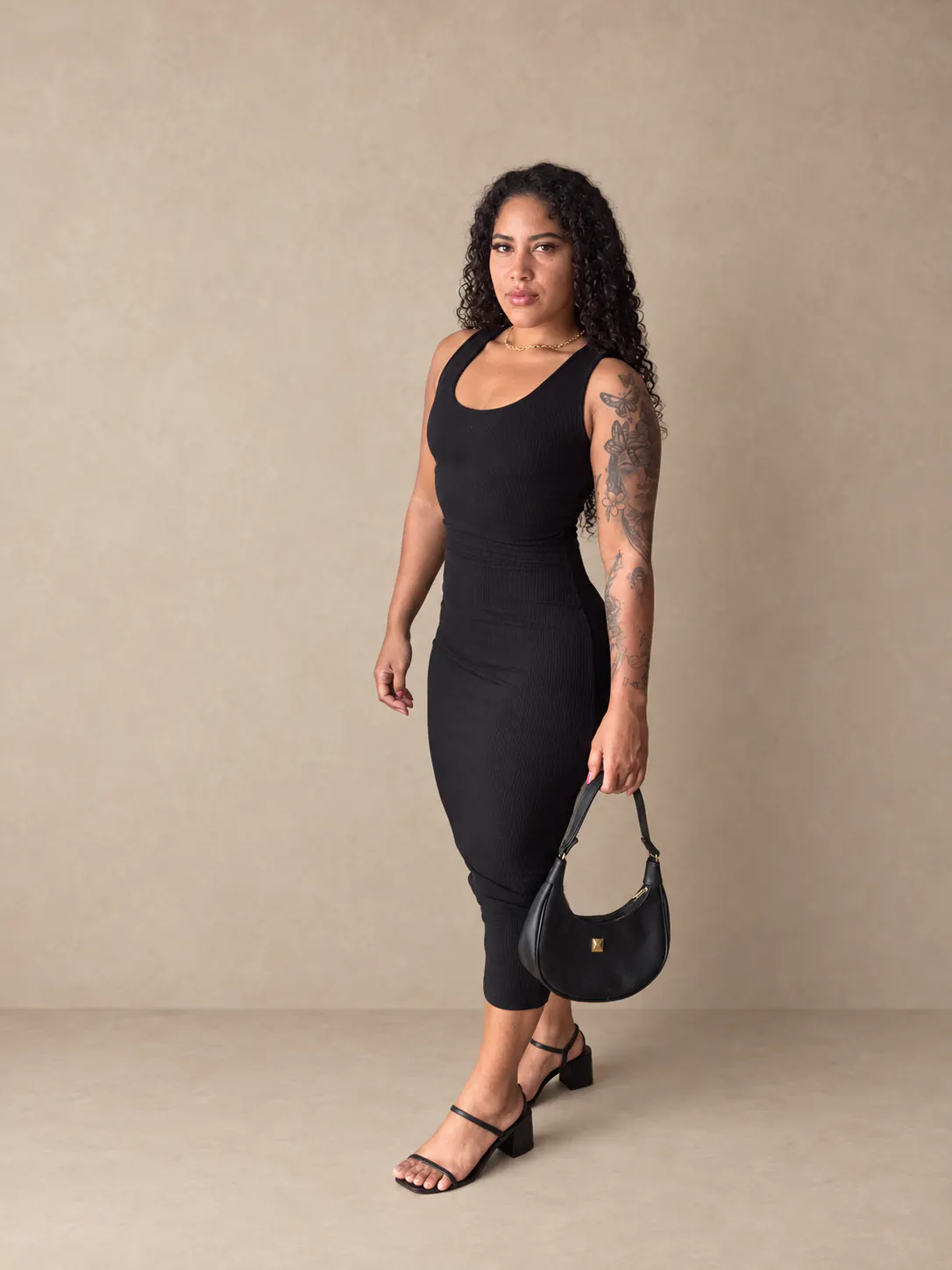 Vestido canelado preto visto de frente em outra composição.