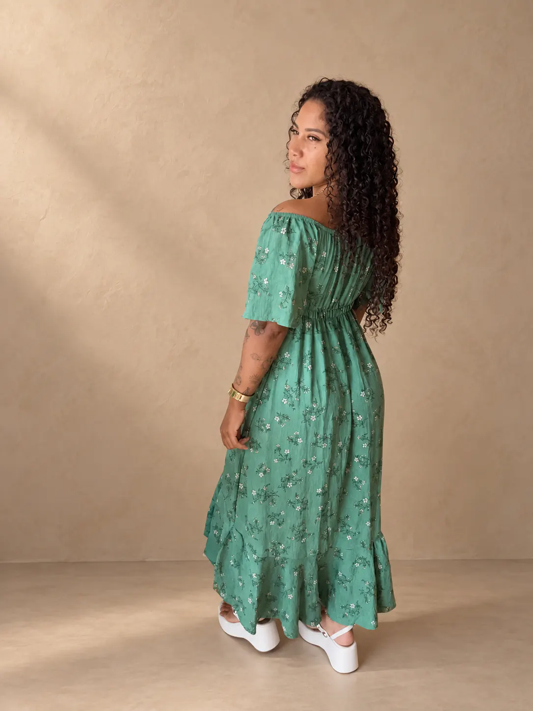 Vestido mídi floral verde-claro visto de costas.
