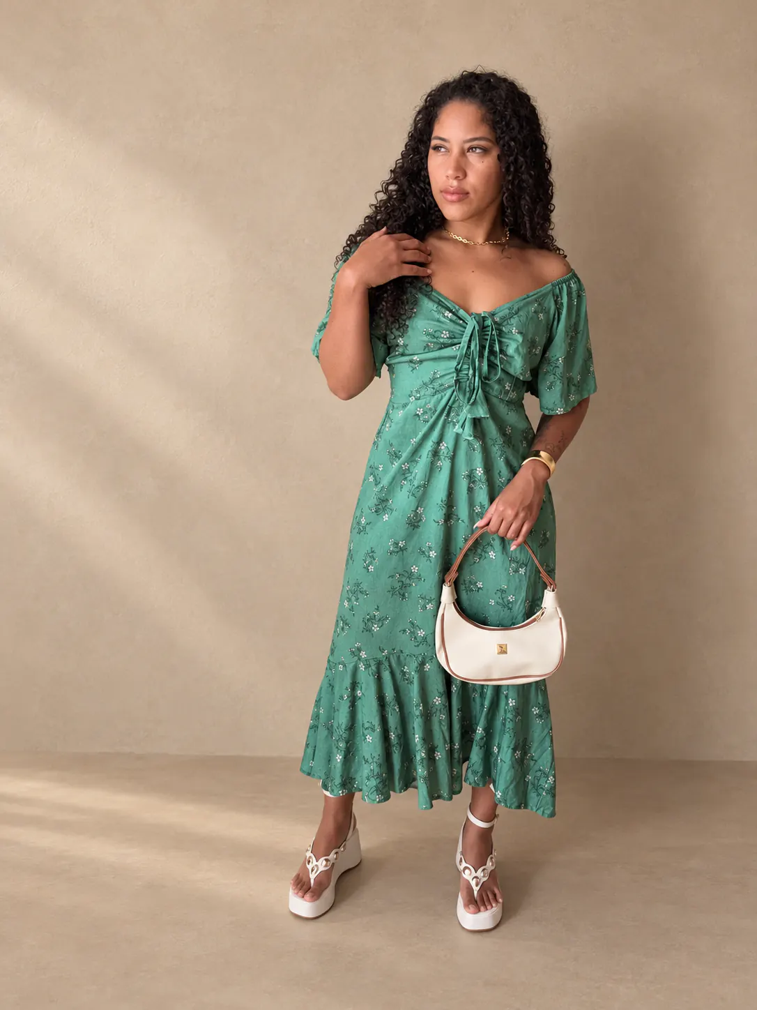Vestido mídi floral verde-claro com amarração, visto de frente.