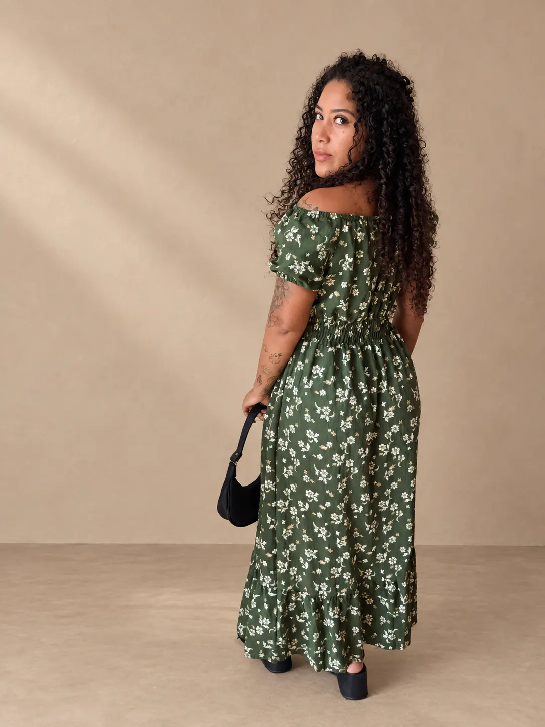 Vestido mídi floral verde-escuro visto de costas.